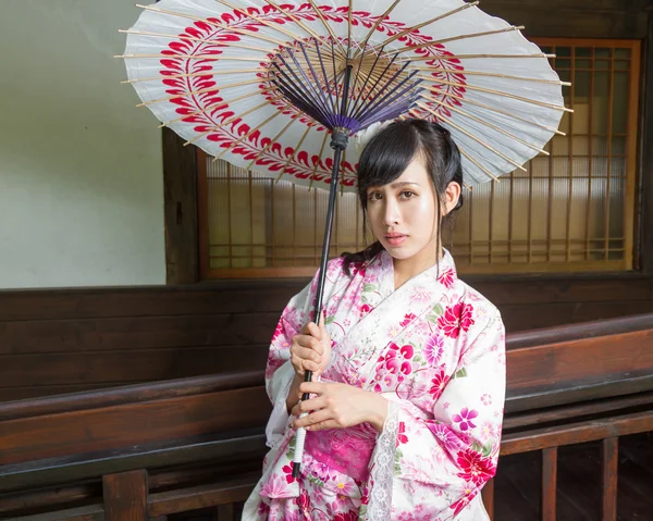 Asiatisk kvinna i kimono innehar paraply — Stockfoto