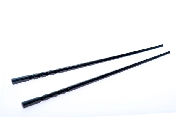 Black chopsticks on white surface — Stock Photo, Image