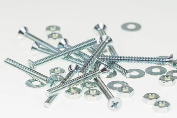 Screws, nuts, and bolts on isolated white background — Stock Photo, Image