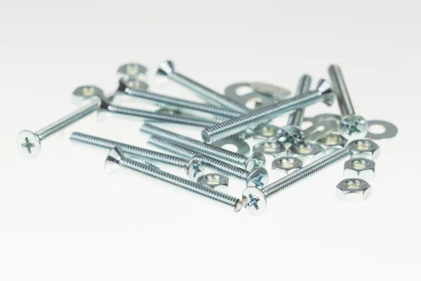 Screws, nuts, and bolts on isolated white background — Stock Photo, Image