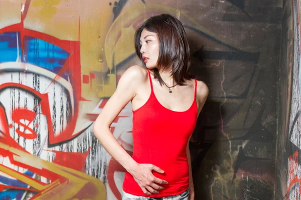 Schöne Chinesin durch Graffiti-Wände — Stockfoto