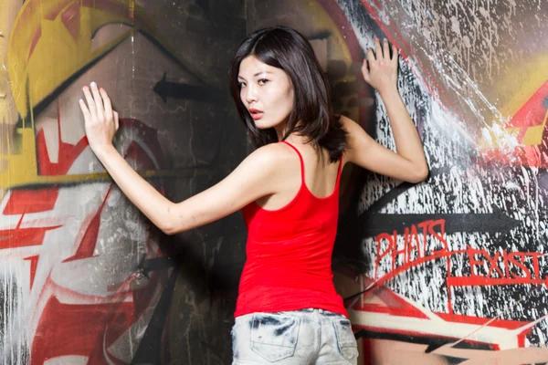 Schöne Chinesin durch Graffiti-Wände — Stockfoto