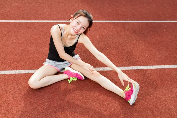 Asiatique femme étirement sur la piste — Photo