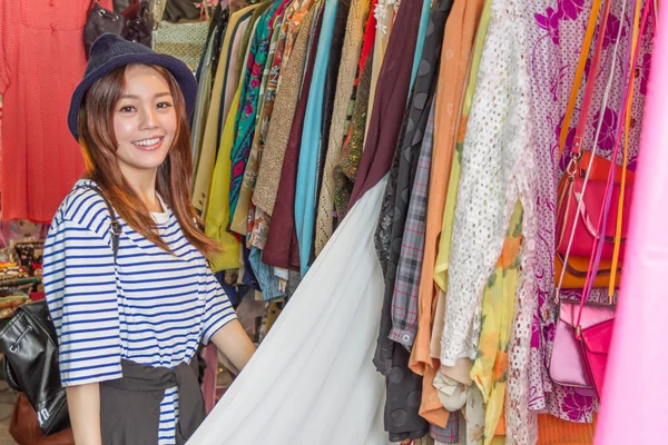 Asian woman looking at clothes on rack — Stock Photo, Image