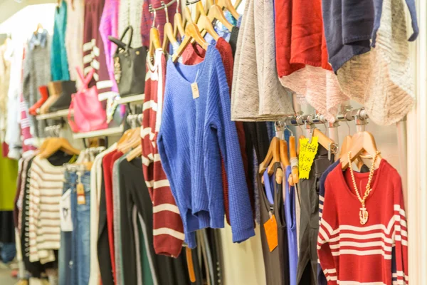 Oblečení na ramínkách na noční trh store — Stock fotografie