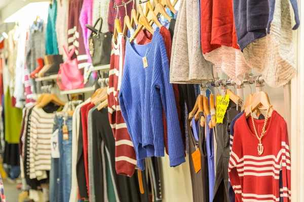 Ropa en perchas en una tienda de mercado nocturno —  Fotos de Stock