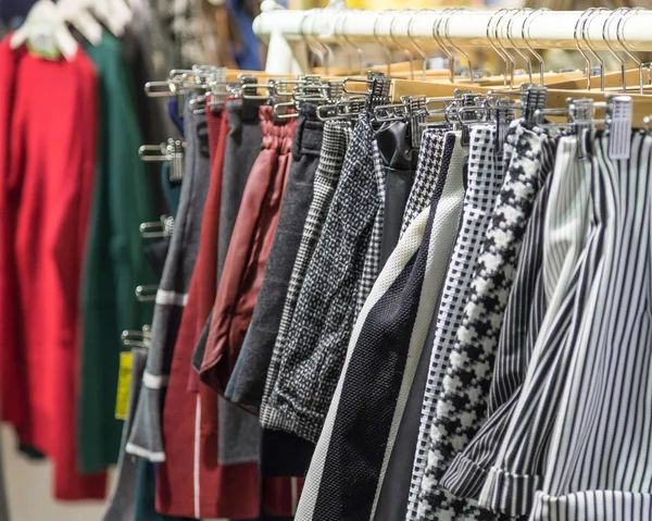 Ropa en perchas en una tienda de mercado nocturno —  Fotos de Stock