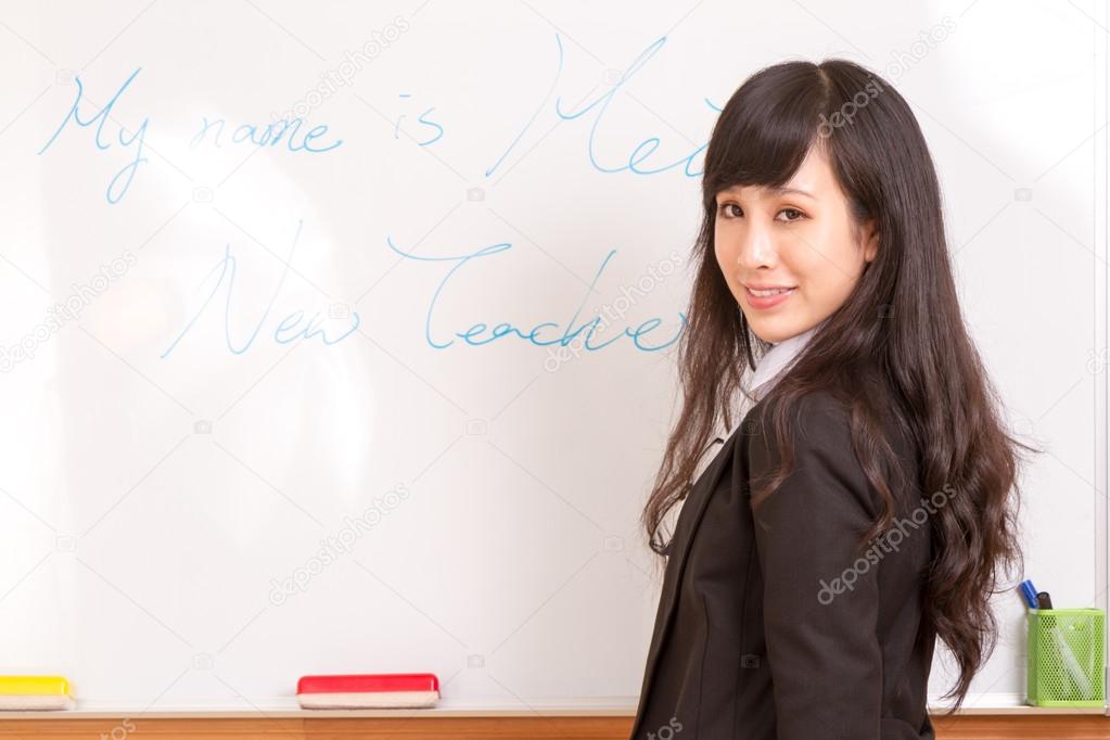 Asian teacher writing on whiteboard
