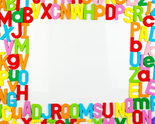 Alphabet magnets forming frame on whiteboard — Stock Photo, Image