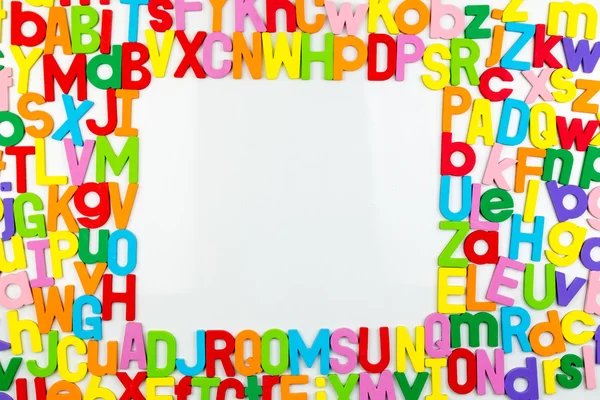Alphabet magnets forming frame on whiteboard — Stock Photo, Image