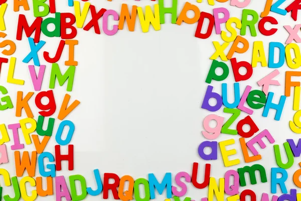 Imanes del alfabeto que forman el marco en pizarra blanca — Foto de Stock