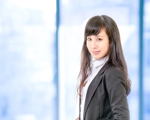 Mujer de negocios china frente a las ventanas de la oficina — Foto de Stock