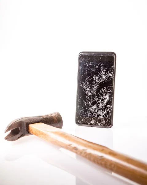 Κατεστραμμένο smartphone με σφυρί που απομονώνονται σε λευκό. — Φωτογραφία Αρχείου