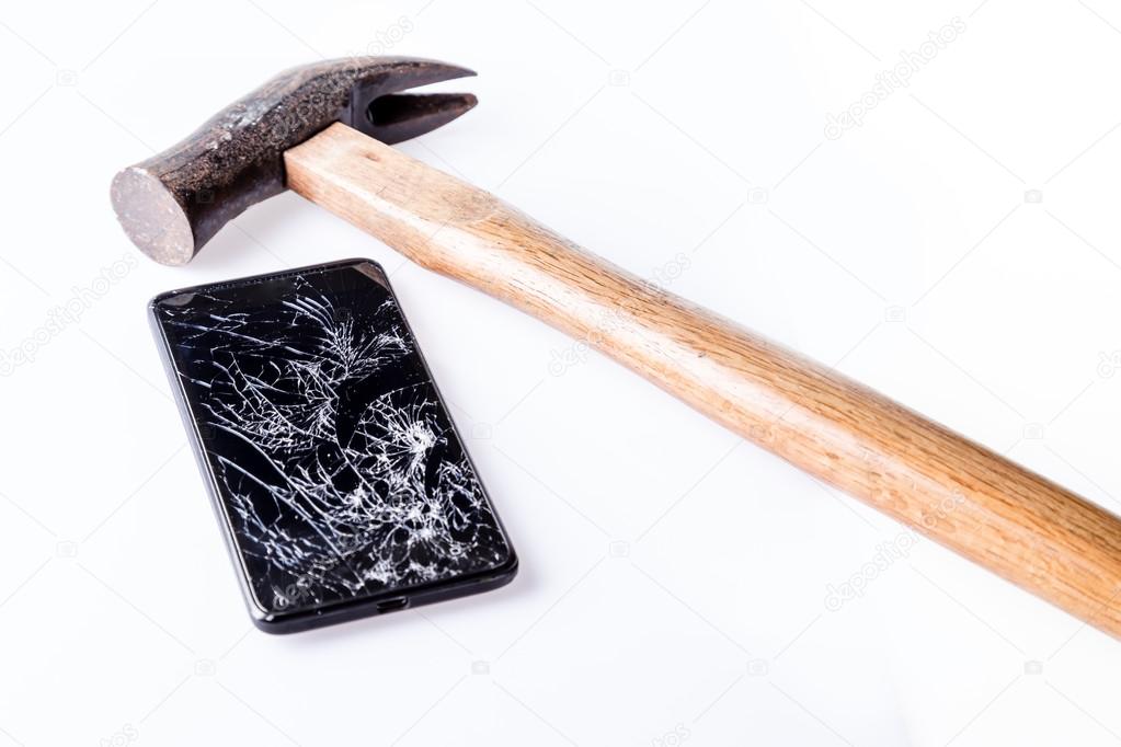 Hammer and  smartphone with broken screen on white. 