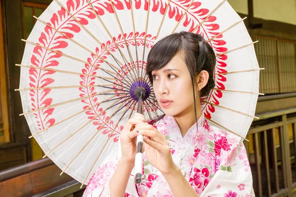 Азіатський жінка в кімоно тримає парасольку — стокове фото