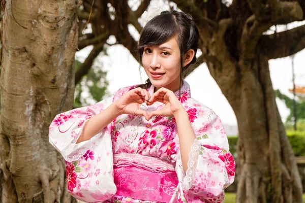 Asiatisk kvinna i kimono i trädgården — Stockfoto