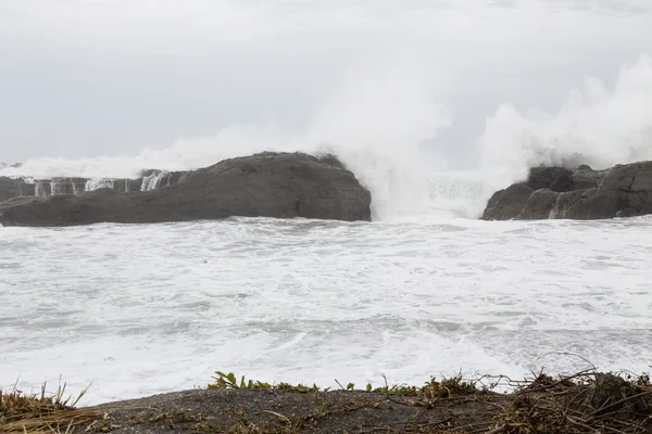 Mar tormentoso con olas estrellándose sobre rocas — Foto de Stock