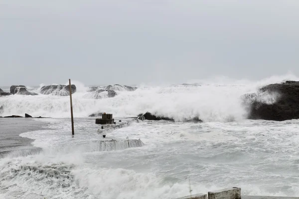 Mar tormentoso con olas estrellándose sobre rocas — Foto de Stock