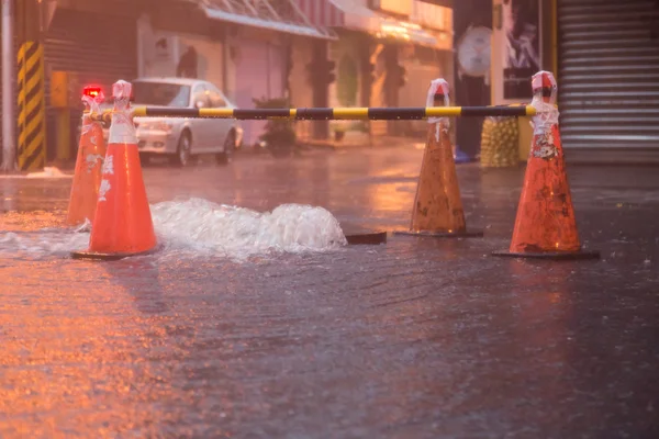 Orange cones around overflowing manhole — Stock Photo, Image