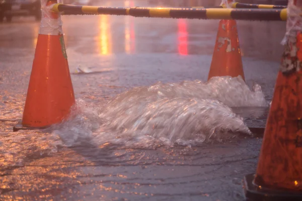 Orange cones around overflowing manhole — Stock Photo, Image