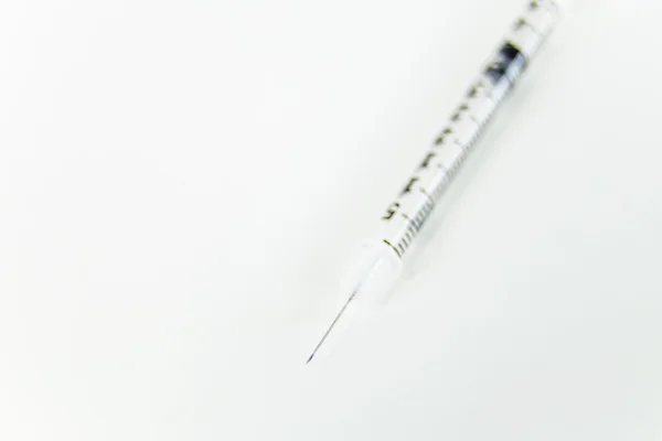 Syringe on white table — Stock Photo, Image