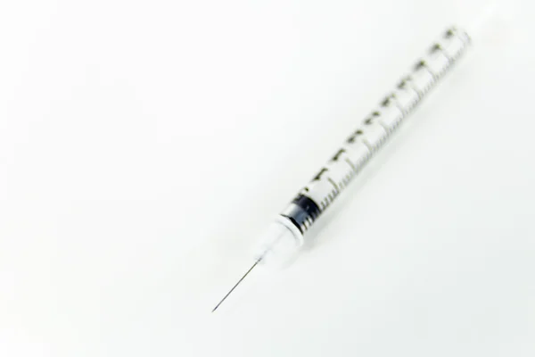 Injekční stříkačka na bílém stole — Stock fotografie