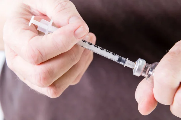 Syringe drawing insulin from vial — Stock Photo, Image
