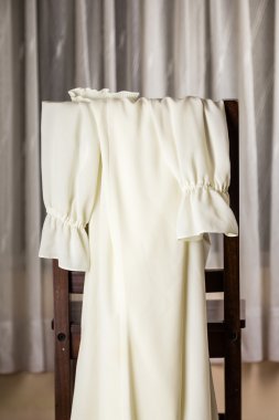 Beyaz sandalye üzerinde bol dökümlü elbise