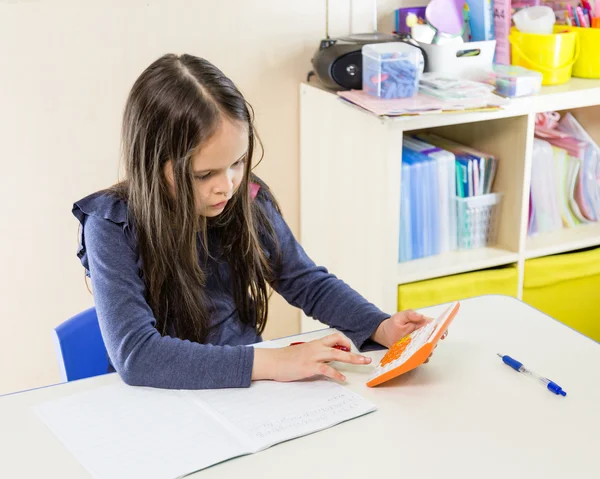 Asian American girl using calculator — Stock Photo, Image