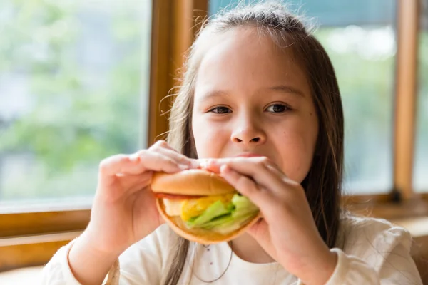 Menina comendo hambúrguer — Fotografia de Stock