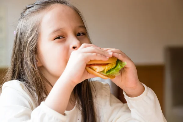 Девушка ест гамбургер — стоковое фото