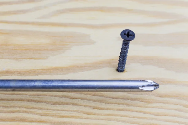 Screw in wood and screwdriver — Stock Photo, Image