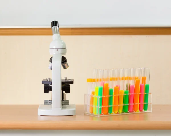 Microscoop en reageerbuizen in science lab — Stockfoto