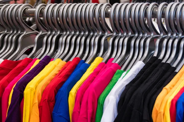 Különböző színes pólók a fogasok — Stock Fotó