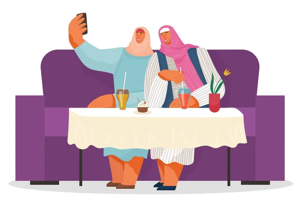 Dos amigas usando hiyabs tomando selfie juntas en el teléfono, mujeres árabes sentadas en el sofá en la cafetería — Vector de stock