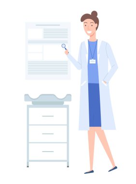 Kadın bir çocuk doktoru elinde özel bir nesne tutuyor. Doktor masasının yanında.