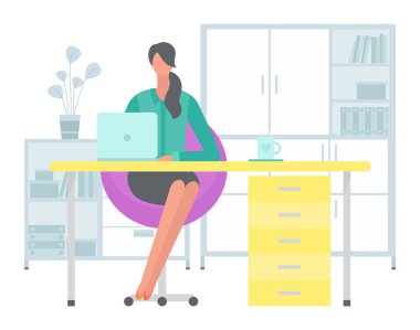 Masadaki koyu renk saçlı genç iş kadını ofis bilgisayarında çalışıyor.