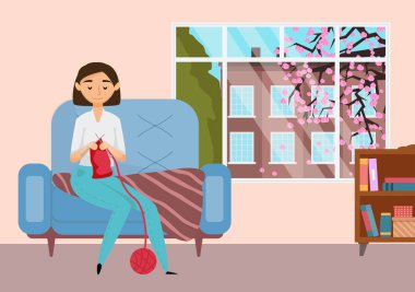 Genç kız örgü örüyor. Kadın koltukta otururken sıcak kıyafetler dikerken eğleniyor.