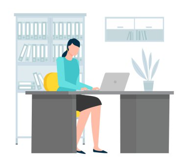 Masadaki koyu renk saçlı genç iş kadını ofis bilgisayarında çalışıyor.