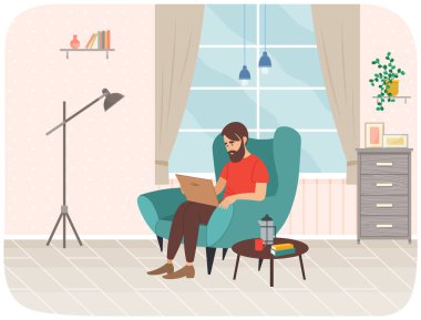 Genç adam dizüstü bilgisayarla koltukta oturuyor, uzaktan çalışıyor, sosyal medyayı izliyor, internete servis yapıyor.