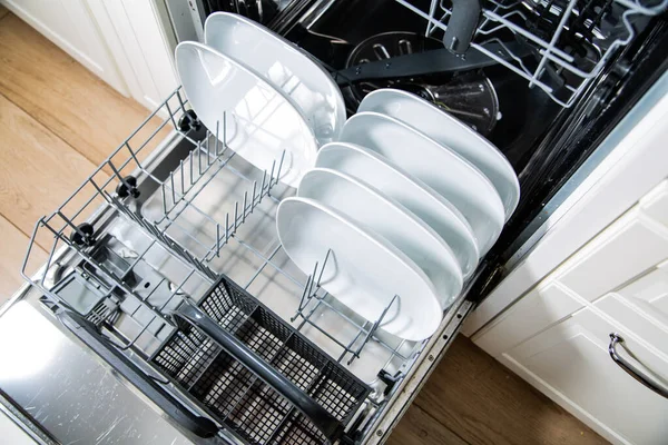 Uma máquina de lavar louça aberta com pratos limpos, vista superior. Aparelho de cozinha moderna. — Fotografia de Stock