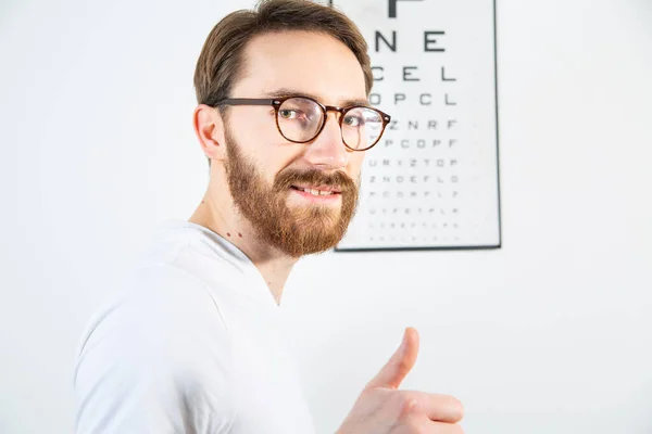 Young Adult Man Smiling Looking Camera Reading Eye Test Chart — Zdjęcie stockowe