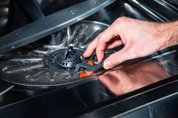 Erkek el bulaşık makinesinden filtre çıkarıyor. — Stok fotoğraf