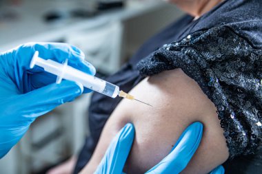 Enjeksiyon yapmaya yakın çekim, bir hastayı kolundan aşılamak. Aşı noktası. Savaş salgını konsepti.