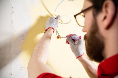 Laying an electrical installation, wiring. An electrician connecting wires in a connector block.
