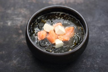 A close-up of a misoshiru - traditional Japanese soup with salmon. 
