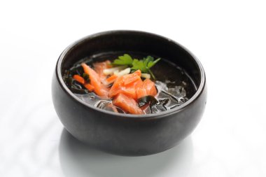 A fish broth. Clear fish soup with a salmon, seasonal vegetables and Japanese spices.