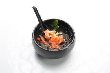 A fish broth. Clear fish soup with a salmon, seasonal vegetables and Japanese spices.