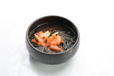Fish broth, soup with salmon, seasonal vegetables and Japanese spices, isolated on white. 