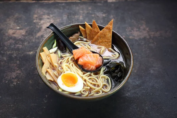 Ramen tradicional japonés con salmón, sobre un fondo negro pedregoso. — Foto de Stock